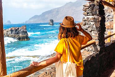 A tourist looking at the pools from the recreational area of La Maceta on the island of El Hierro, Canary Islands