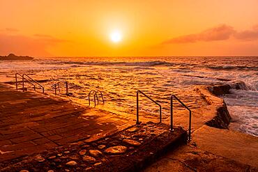 Waves at sunset in the natural pools of La Maceta in El Hierro en la Frontera, Canary Islands