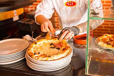 Artisan pizza oven. Chef preparing the pizza to sell it, pizza hot and ready for customers