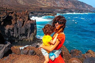 A mother with her son on vacation on the volcanic trail in the village of Tamaduste on the island of El Hierro, Canary Islands, Spain, Europe