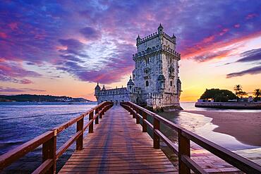 Belem Tower or Tower of St Vincent, famous tourist landmark of Lisboa and tourism attraction, on the bank of the Tagus River Tejo in evening dusk after sunset with dramatic sky. Lisbon, Portugal, Europe