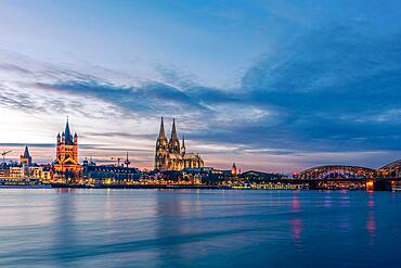 Panoramic view of Cologne Cathedral with Hohenzollern Bridge at nightfall, Germany, Europe