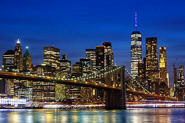 New York City skyline of Manhattan with Brooklyn Bridge and World Trade Center skyscraper at night in New York, USA, North America