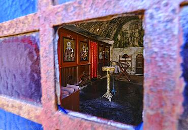 Interior of Orthodox cave church of St John the Hermit in abandoned Katholiko monastery in Avlaki gorge of Akrotiri peninsula, Chania, Crete, Greece. Shot through open window. Selective focus