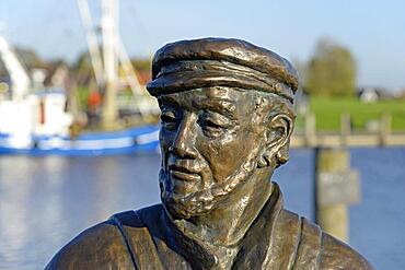 Bronze sculpture, The Net Tinker, in the harbour of Greetsiel, North Sea, Lower Saxony, Germany, Europe