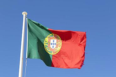 National flag of Portugal against a blue sky in Sagres, Faro district, Algarve, Portugal, Europe