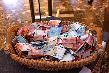 A large basket of banknotes various euro notes lying on top of each other