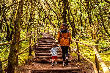 Mother and son trekking on some stairs along a path in the Garajonay natural park on La Gomera, Canary Islands