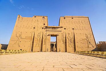 Facade with drawing of pharaohs of the Temple of Edfu in the city of Edfu, Egypt. On the bank of the Nile river, geco-Roman construction, temple dedicated to Huros