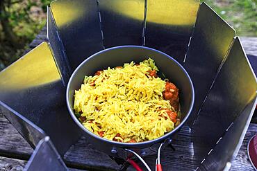 Rice with curcuma in a saucepan, stew on a camping cooker with windbreak, gas cooker, easy outdoor cooking, outdoors, England, Great Britain