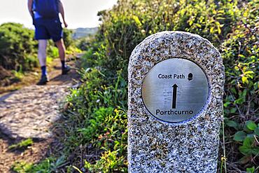 Walkers next to waymarker, South West Coast Path, signpost to Porthcurno, Treen, St Levan, Cornwall, England, United Kingdom, Europe