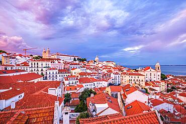 View of Lisbon famous view from Miradouro de Santa Luzia tourist viewpoint over Alfama old city district on sunset with dramatic overcast sky. Lisbon, Portugal, Europe