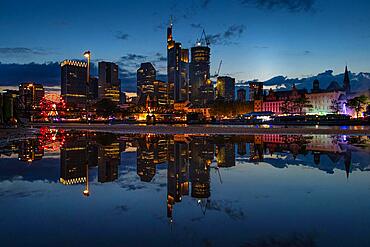 The colourful lights of the Mainfest are reflected in a puddle. The Mainfest on the Mainkai, Fahrtor and Roemerberg is one of Frankfurt's oldest public festivals. The official opening takes place in 2023 on 04 August at 6pm at the Gerechtigkeitsbrunnen on Roemerberg. The festival ends with a big fireworks display over the Main on Monday, 07.08.2023., Mainufer, Frankfurt am Main, Hesse, Germany, Europe