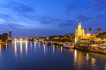 On the banks of the Guadalquivir River with the historic Torre del Oro tower at dusk, Seville, Andalucia, Spain, Europe