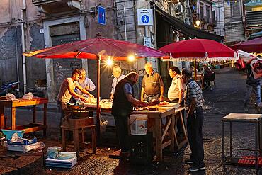 Early morning, fish market, illuminated stall, vendor, old town, Catania, east coast, Sicily, Italy, Europe