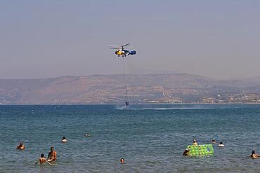 Helicopter, helicopter, fire-fighting helicopter, fire, helicopter refuelling water from the sea, bathing tourists, Georgioupolis, Crete, Greece, Europe