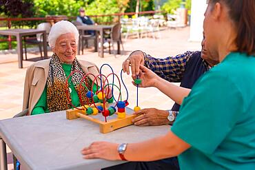 Two elderly people in the garden of a nursing home or retirement home playing with games to improve mobility