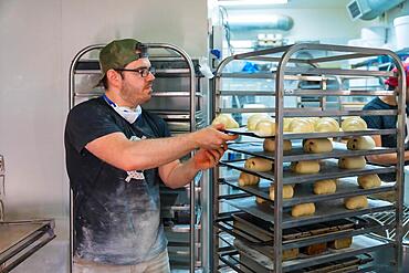 Baker of bakery in workshop workshop of artisan bakery preparing croissant and neapolitan