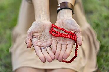 Close-up of opened woman's hands showing a japa mala