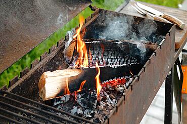 Metal grill with burning log and fork and knife for steak