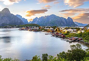 Village view of the fishing village Reine, Traditional red Rorbuer cabins, at sunset, rocky mountains in the back, Lofoten, Nordland, Norway, Europe