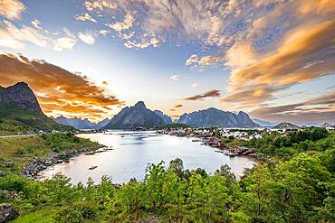 Village view of the fishing village Reine, Traditional red Rorbuer cabins, at sunset, rocky mountains in the back, Lofoten, Nordland, Norway, Europe