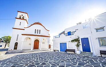 Greek Orthodox church Metamorfosi Sotiros, with sun star, white Cycladic houses with blue doors, alleys of the village Marpissa, Paros, Cyclades, Greece, Europe