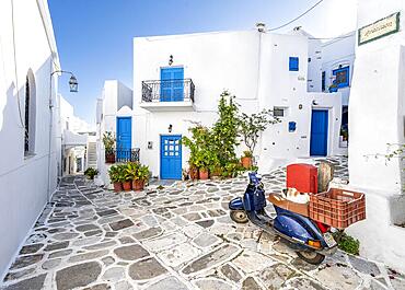 Blue Vespa with cats, white Cycladic houses with blue doors and windows and flower pots, picturesque alleys of the village of Lefkes, Paros, Cyclades, Greece, Europe