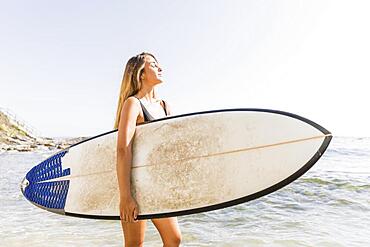 Pretty woman swimsuit walking with surfboard sea