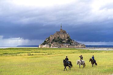 Horsemen in front of the monastery mountain Mont Saint-Michel, Le Mont-Saint-Michel, Normandy, France, Europe