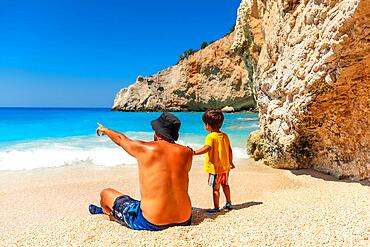 A father and child having fun on Porto Katsiki beach in summer vacation Lefkada island, Greece, Europe