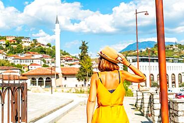 A young woman walking through the city of Berat in Albania in the summer holidays, the city of a thousand windows