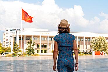 A tourist visiting the Palace of Culture or Opera in Skanderbeg Square in Tirana. Albania