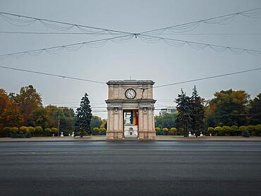 Triumphal Arch in Chisinau city, Moldova. Autumn season view from the street to the landmark in a rainy day