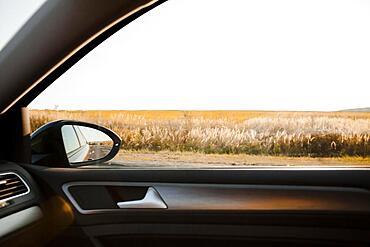 Sunny view field from elegant car