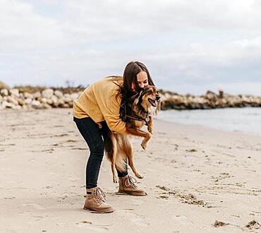 Woman playing with dog beach