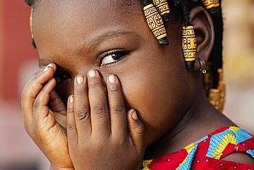 Close up african girl covering her face