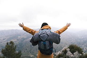 Female backpacker standing top mountain loving nature