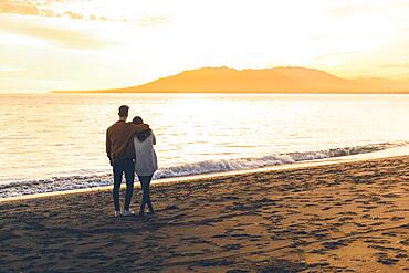 Young couple hugging sea shore