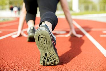 Young woman runner getting ready run track