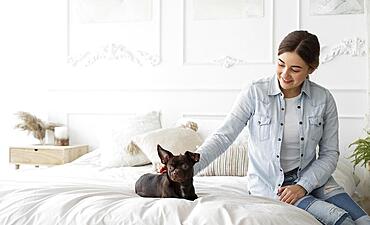 Medium shot girl petting dog bed