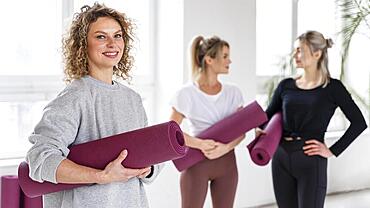 Medium shot smiley women with yoga mats