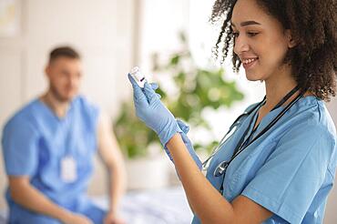 Female doctor preparing vaccination her colleague