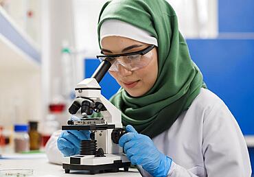 Female scientist with hijab microscope laboratory