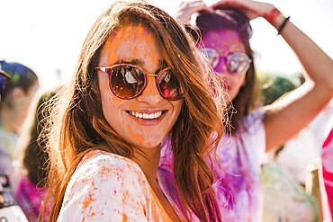 Orange holi color woman s face wearing sunglasses