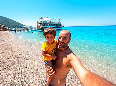 Father and son on the paradise beach of Kroreza or Krorez seen from the boat on the Albanian riviera in Sarande, Albania, Europe