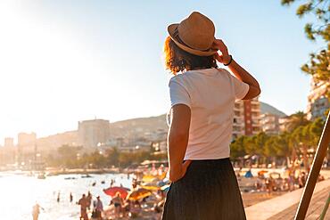 Portrait of a tourist woman in the sunset of Sarande or Saranda in the Albanian riviera walking along the boulevard, Albania, Europe