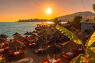 Beautiful resort with umbrellas by the sea at sunset in Sarande or Saranda on the Albanian riviera, Albania, Europe