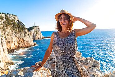 A woman in the sunset at the Ducato Lighthouse or Cape Lefkas in the southern area of the island of Lefkada. Greece