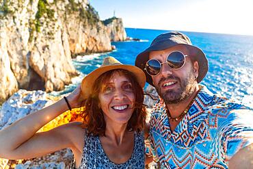 Selfie of a couple of tourists at the Ducato Lefkas Lighthouse or Cape in the southern area of the island of Lefkada. Greece